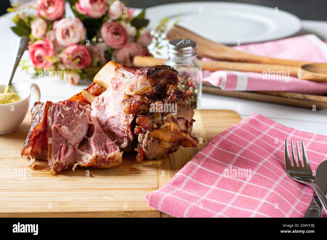 grilled knuckle of pork with mustard on a wooden cutting board, german schweinshaxe Stock Photo