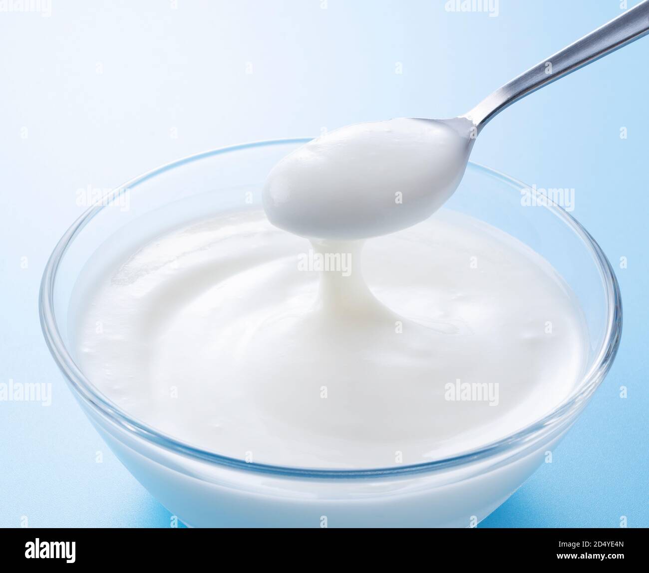 Yogurt in a glass bowl and a spoonful of yogurt Stock Photo Alamy