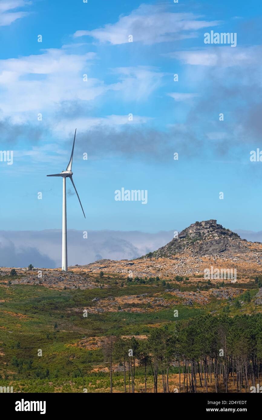 View of a wind turbines on top of mountains, cloudy sky as background ...