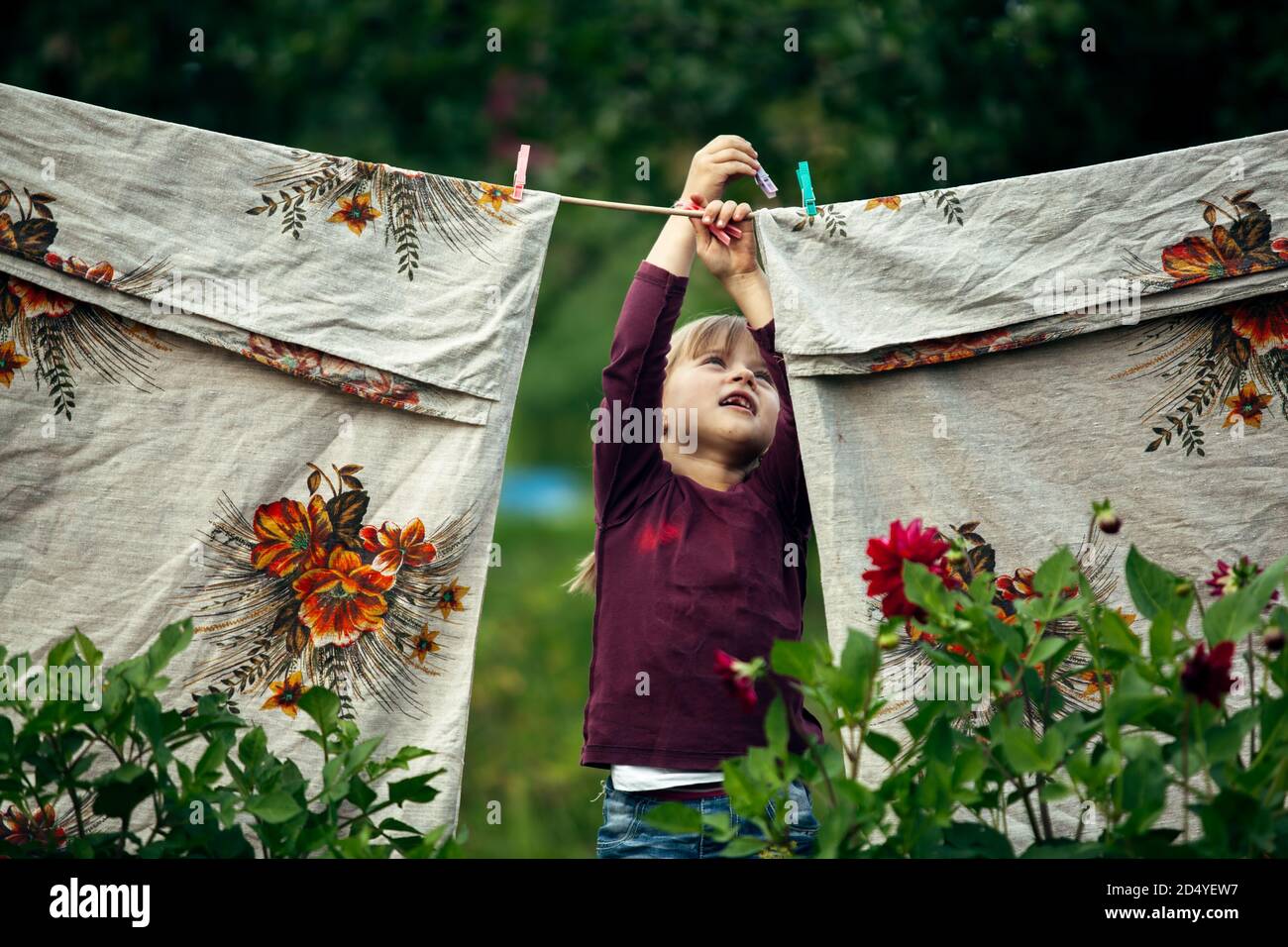 Little cute funny girl with clothespin and the clothesline Stock Photo