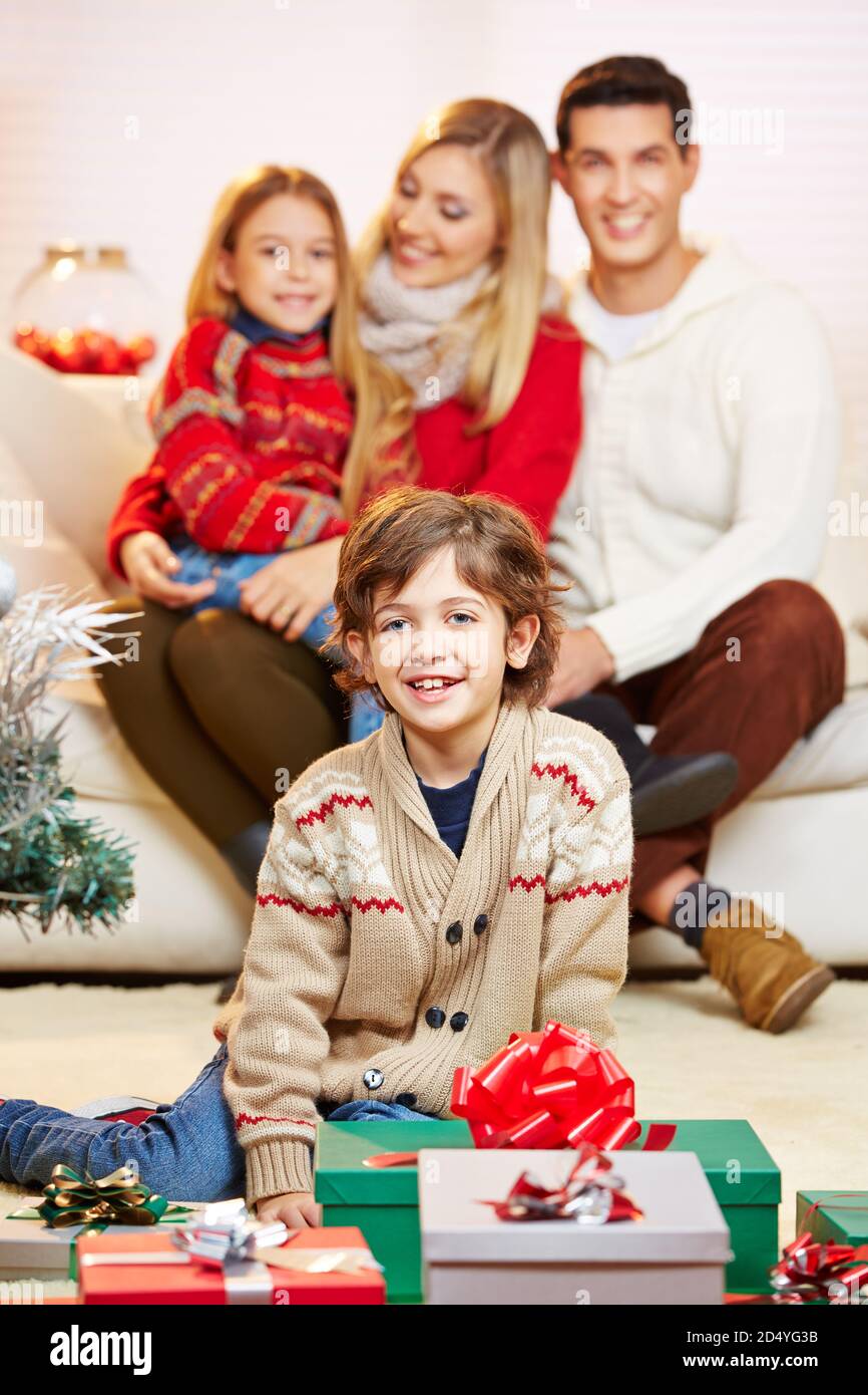 Laughing boy in front of his family's presents for Christmas Stock Photo