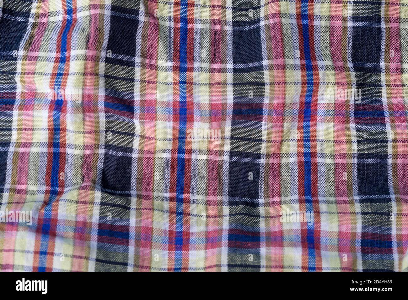 Folded crumpled multicolored checkered cotton fabric background texture