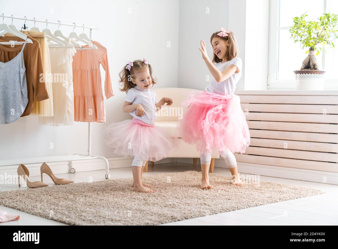 Happy girls dressing up at home. Funny lovely children are having fun