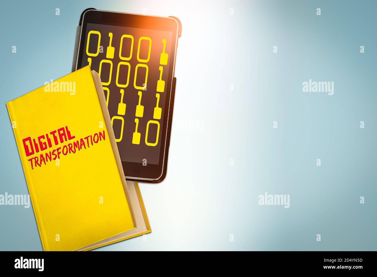 Image of Yellow Book and a Tablet Computer showing the Text Transformation Stock Photo