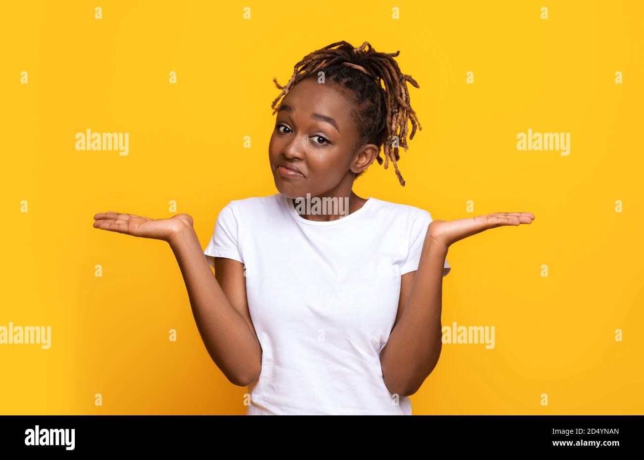 Confused black woman manraising her hands and looking at camera Stock Photo