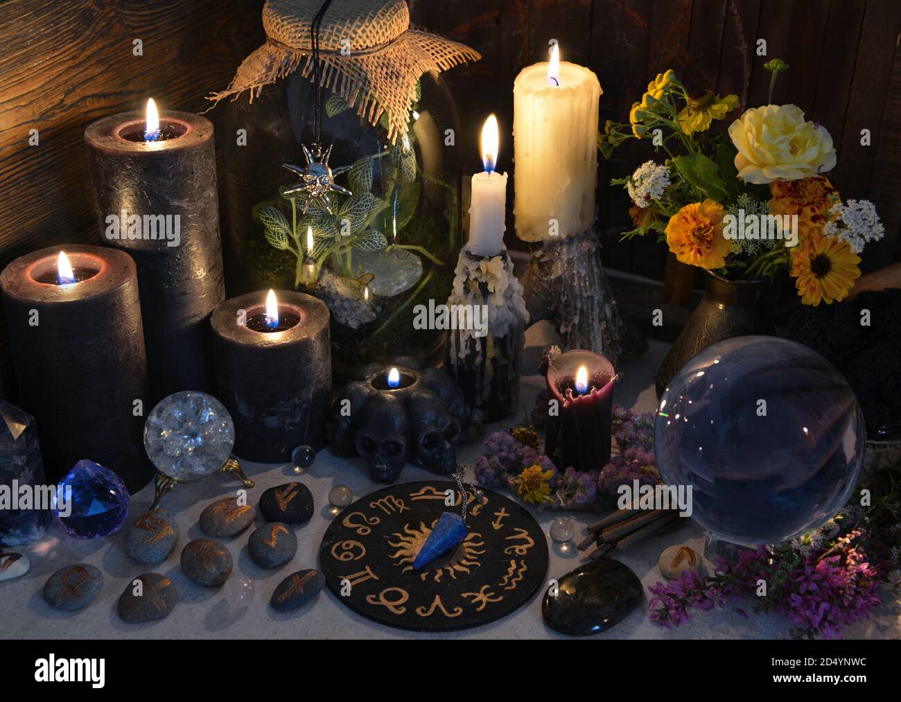 Mysterious still life with black candles, runes and zodiac chart on witch table. Esoteric, gothic and occult background with magic objects. Halloween Stock Photo