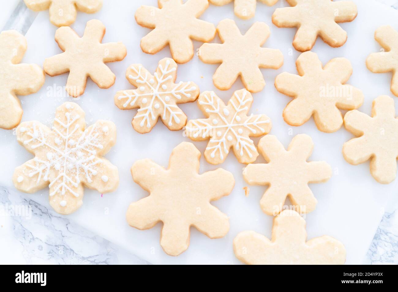 Decorating Christmas sugar cookies with royal icing and sprinkles Stock