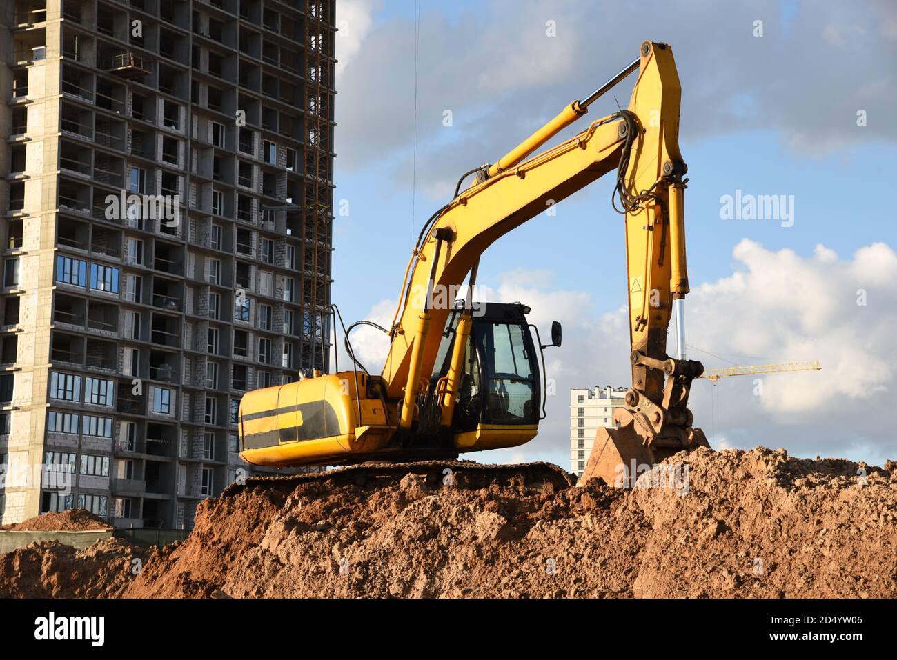 Excavator during Earthmoving Works at construction site. Backhoe digs ...
