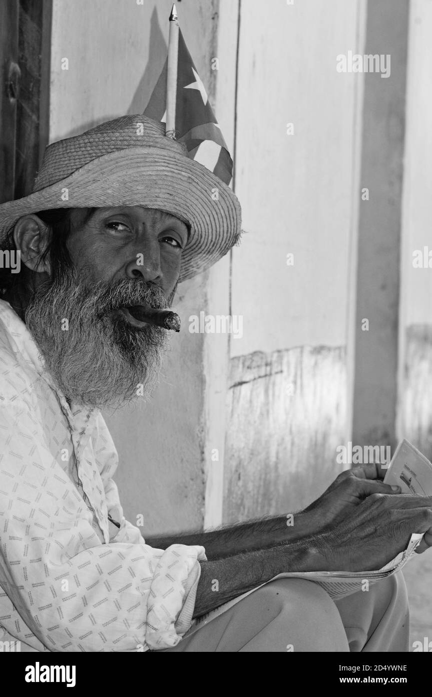 Rauchender und die Parteizeitung lesender kubanischer Patriot in Havanna. Smoking and Gran Ma redaing cuban patriot in Havanna-City Stock Photo
