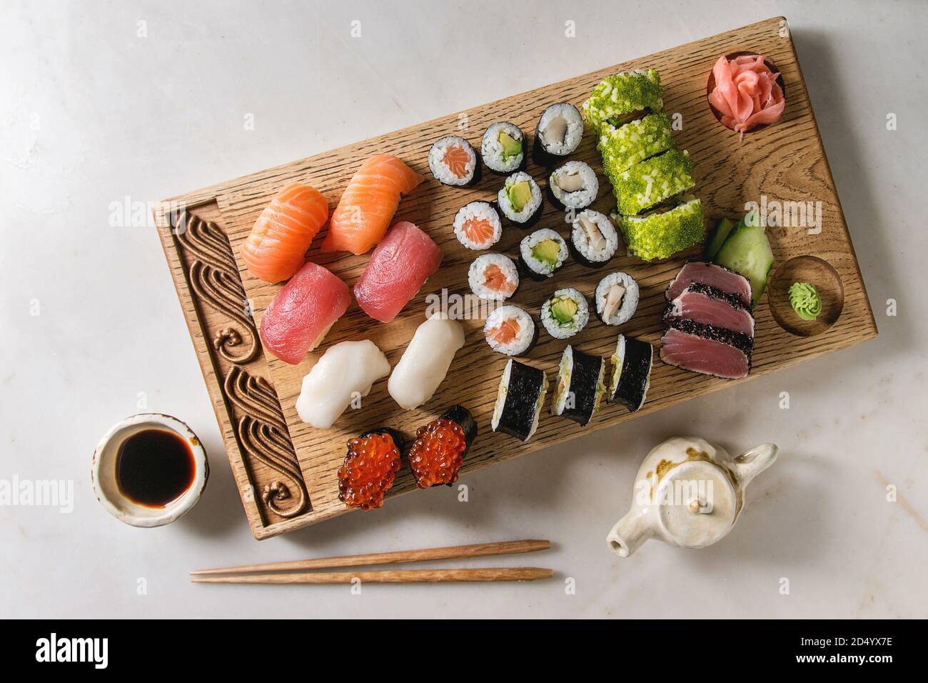 Sushi Set nigiri and sushi rolls on wooden serving board with soy