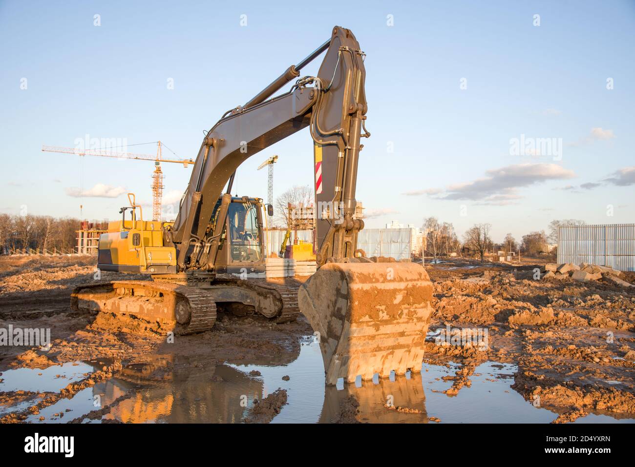 Excavator during Earthmoving Works at construction site. Backhoe digs ...