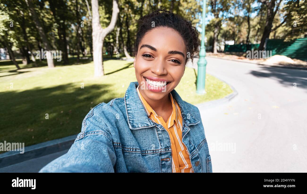 Positive Black Woman Making Selfie Smiling To Camera Outdoors, Panorama Stock Photo
