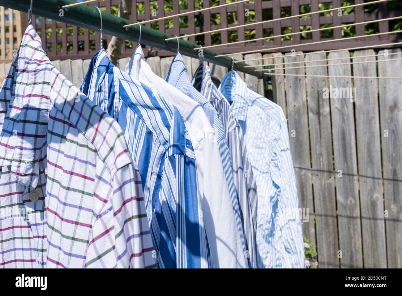 https://c8.alamy.com/comp/2D500NT/a-collection-of-colourful-business-shirts-hanging-with-coat-hangers-on-a-washing-or-clothes-line-in-the-australian-sun-2D500NT.jpg