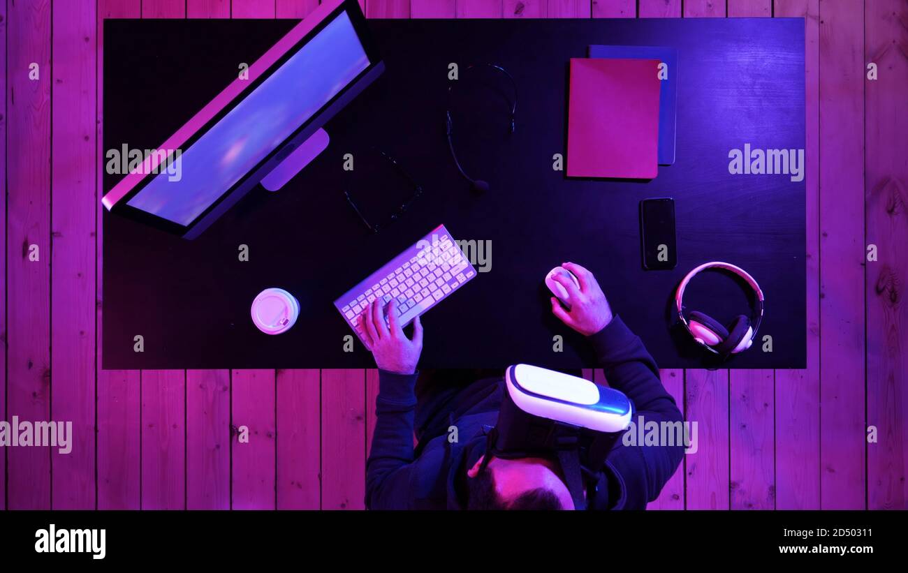 Young bearded man in VR-headset playing a game. Stock Photo