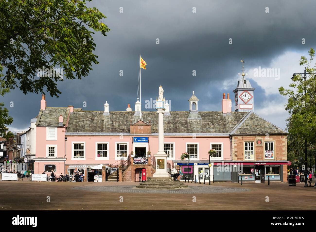 Old Town Hall pink building with people sitting outside cafes in pedestrianised city centre. Market Square, Carlisle, Cumbria, England, UK, Britain Stock Photo