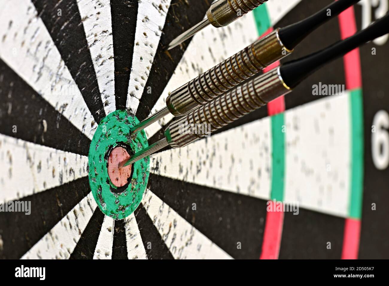 Three darts in a target. One in the right center. Randomly spaced three darts in the target. Ready to play. The game underway. Stock Photo