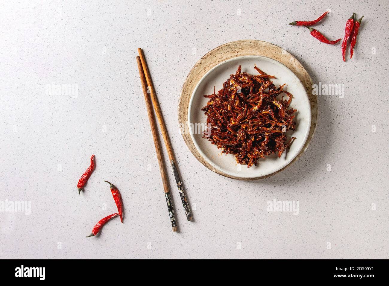 Vietnamese traditional hot spicy anchovies fish snack in ceramic plates
