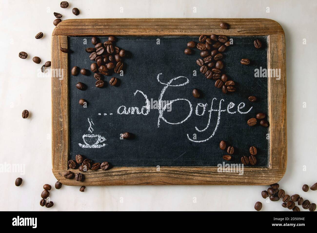 Coffee beans on vintage chalkboard with lettering over white marble