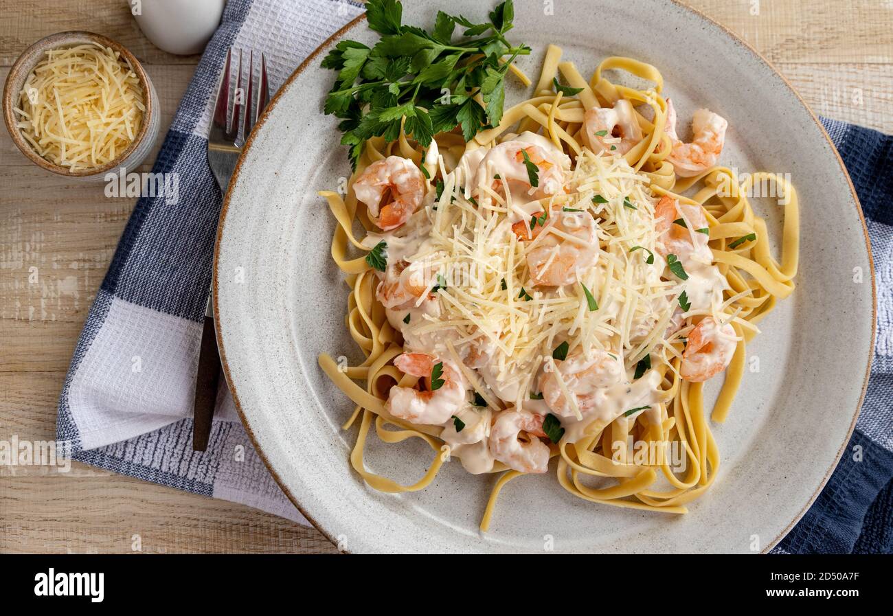 Creamy fettuccine alfredo with shrimp and shredded parmesan cheese on a