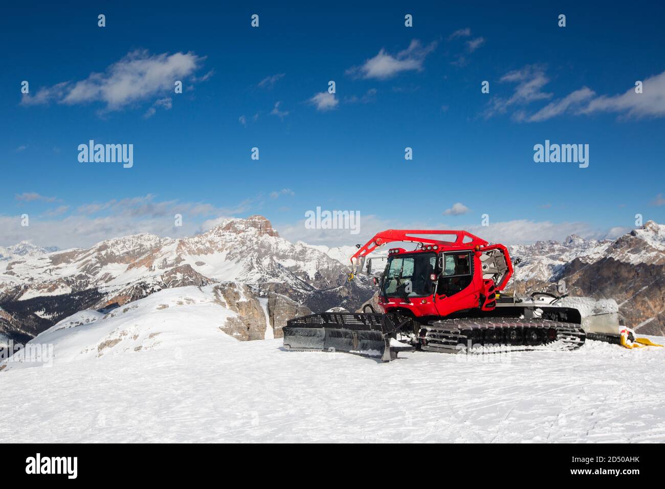 Red modern snowcat ratrack with snowplow snow grooming machine preparing ski slope piste hill at alpine skiing winter resort Cortina d'Ampezzo in Ital Stock Photo