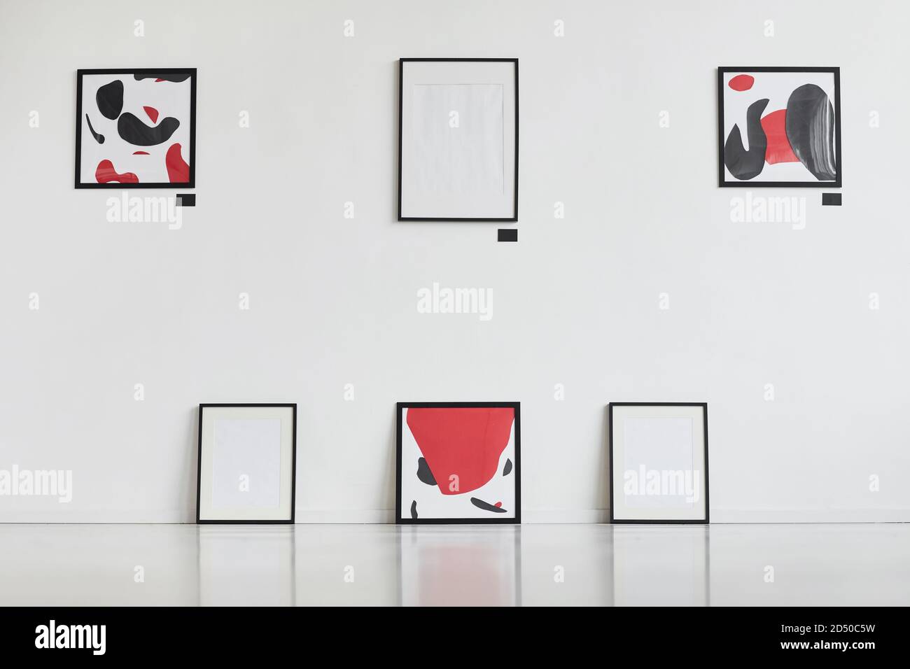 Graphic background image of modern abstract paintings with black and red hanging on white wall in art gallery exhibition, copy space Stock Photo