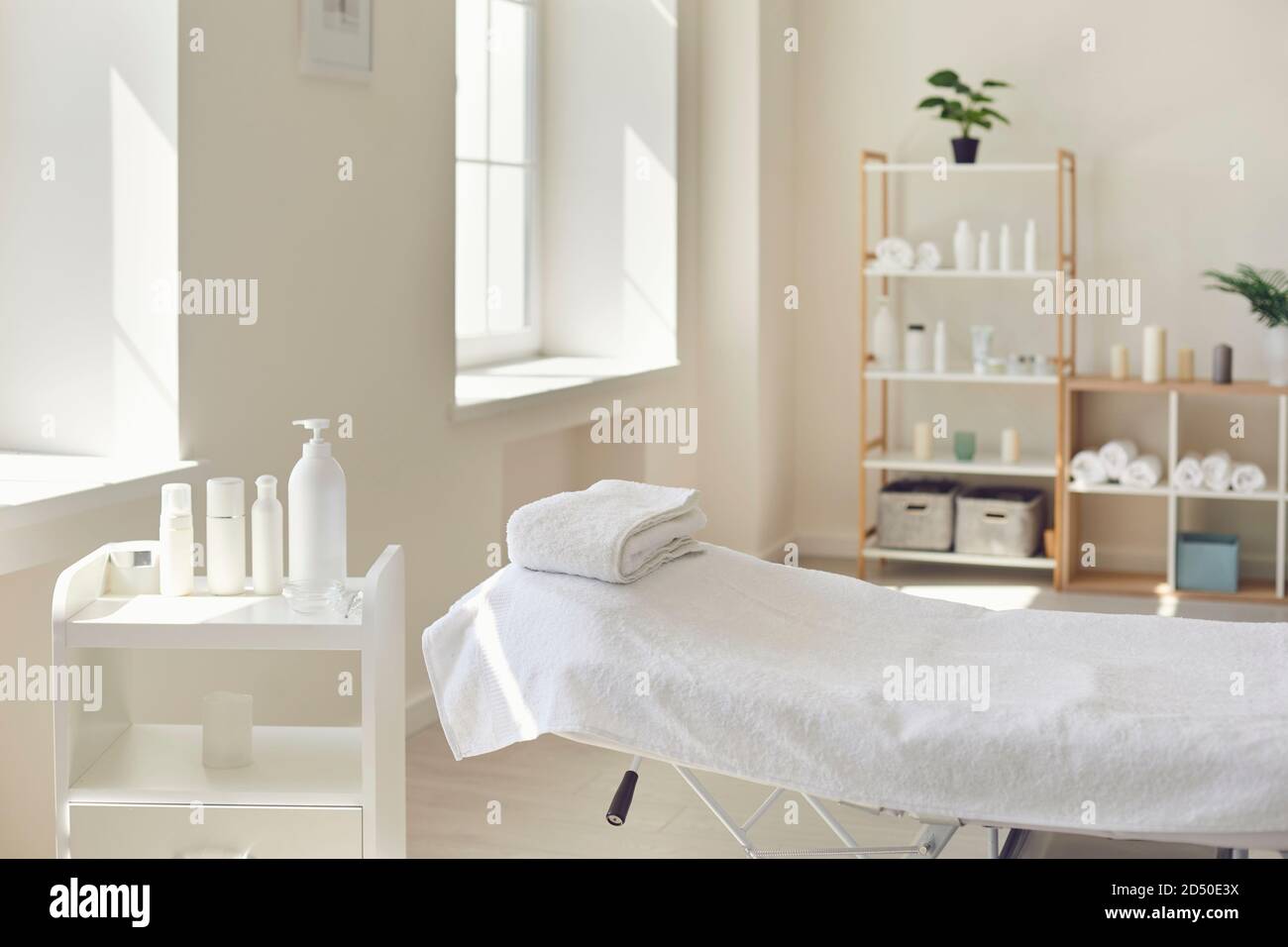 Massage room or beauty parlor with empty bed and ready set of organic skincare products Stock Photo