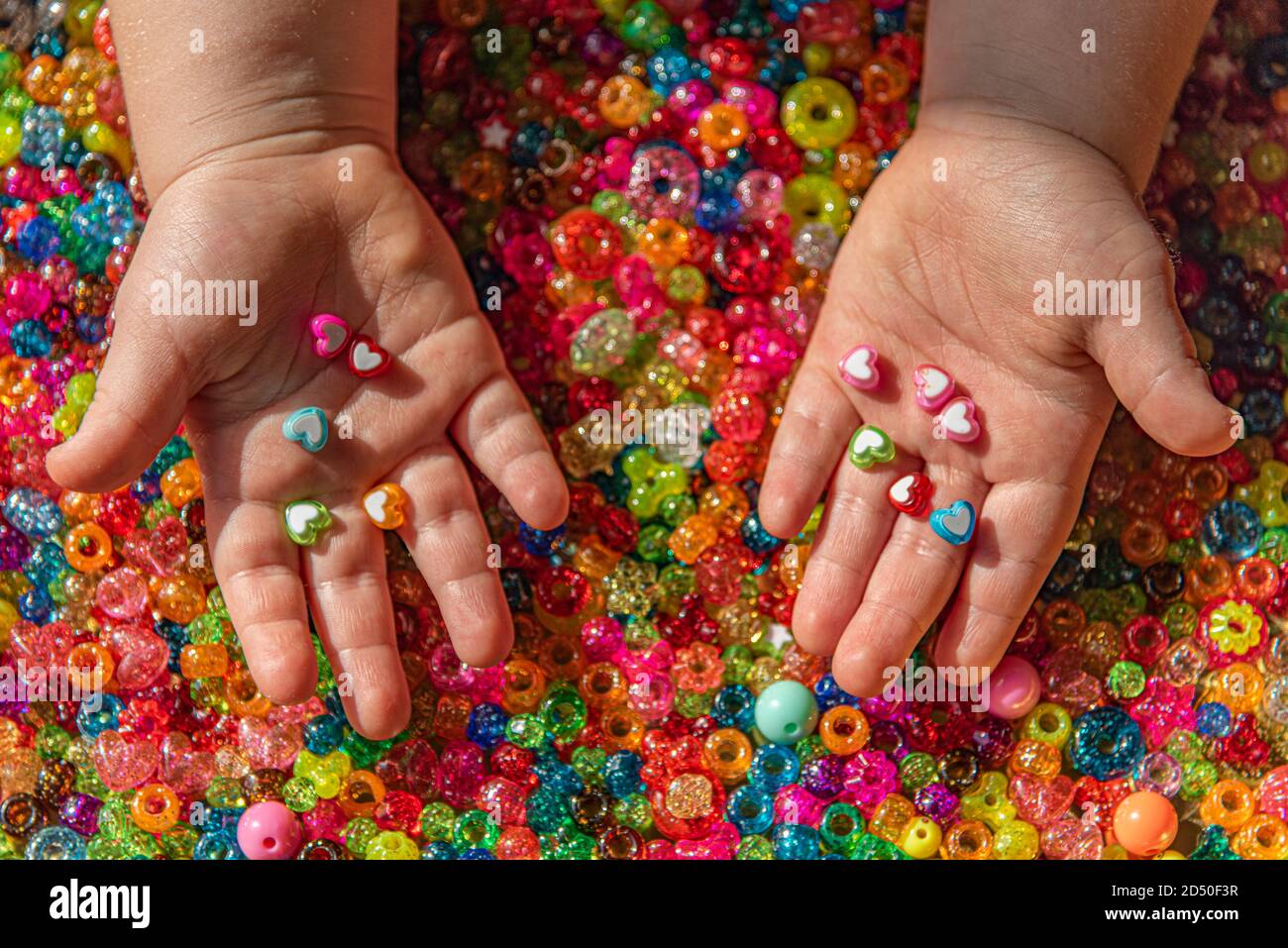 Colored beads in child's palms. A very colorful background of