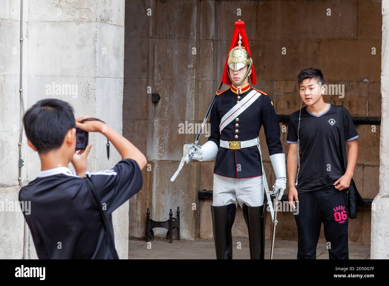 London, UK, July 1, 2012 : Household cavalry soldier on guard at Horse Guards Parade in Whitehall being photographed by tourists which is a popular tr Stock Photo