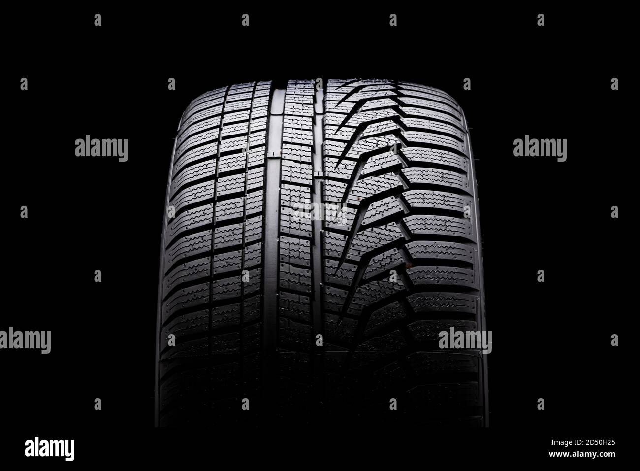 winter tire front view. Asymmetric tread pattern. re-inflating tires for the season. close-up black background Stock Photo