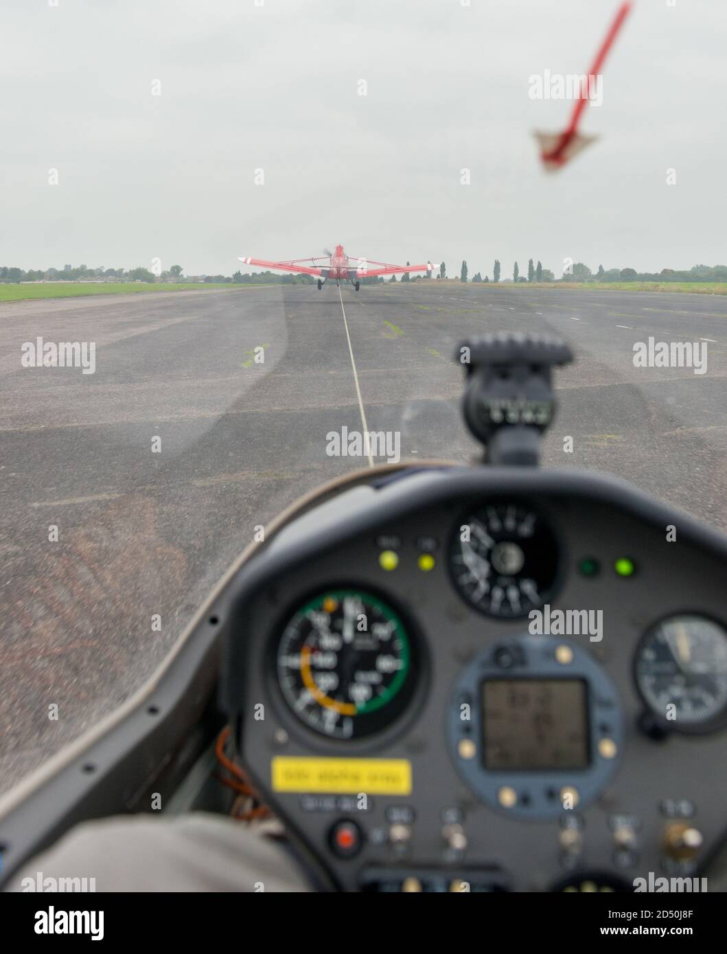 View of a glider take off from the cockpit as it is towed into the air by a single seat airplane Stock Photo