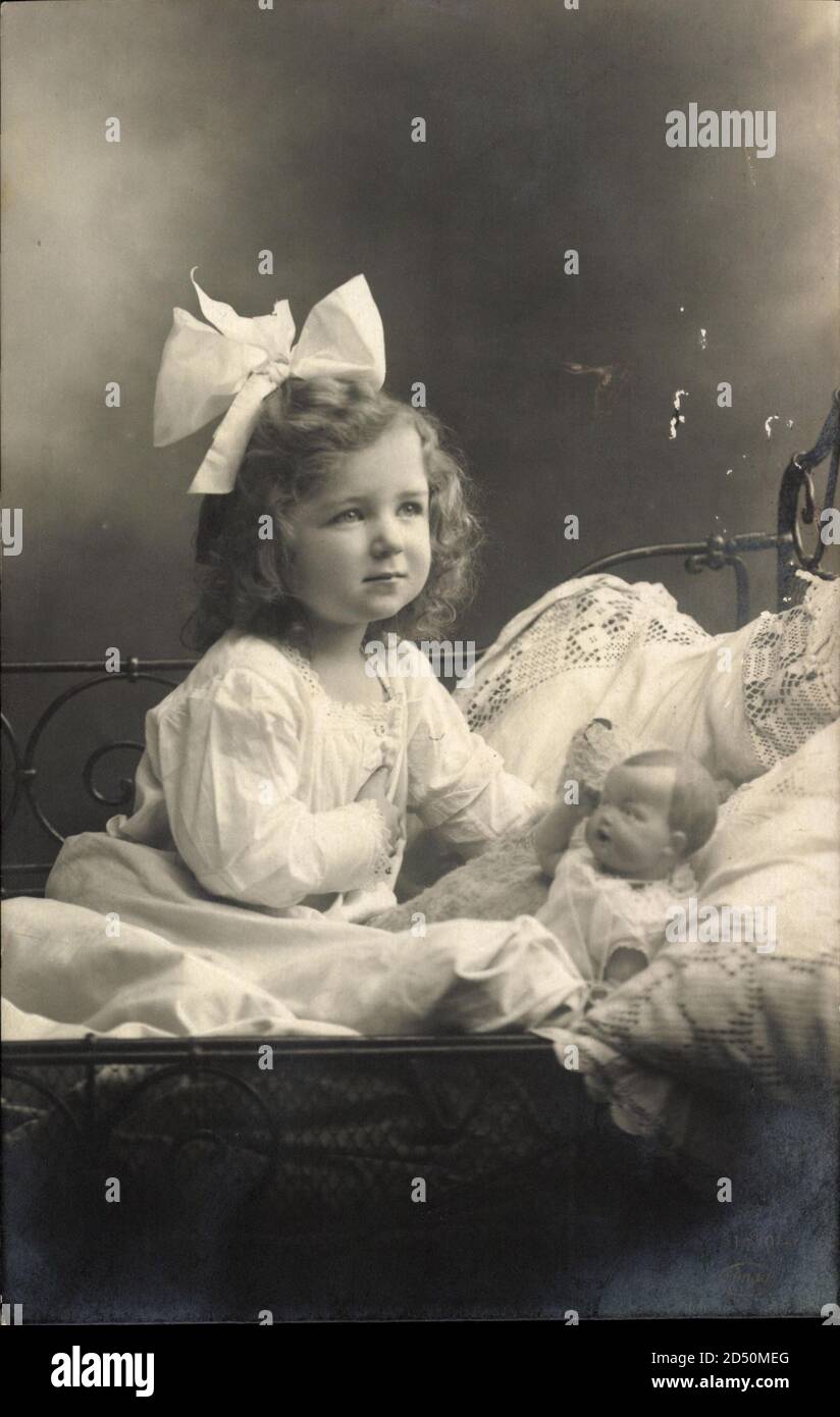 Kleines Mädchen mit Haarschleife, Puppe, Spielzeug, Kinderbett | usage  worldwide Stock Photo - Alamy