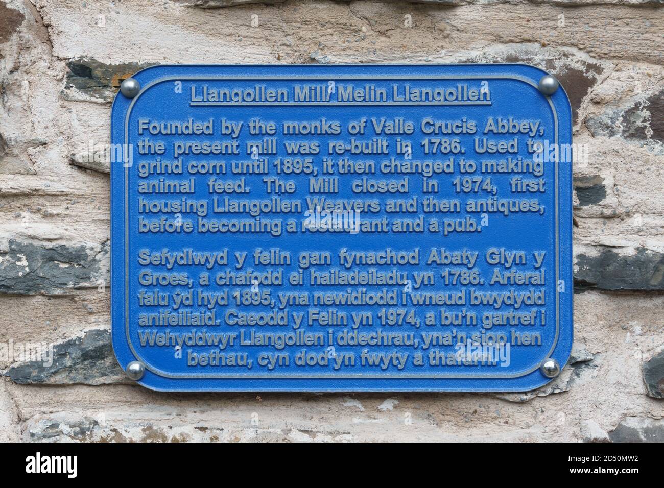 Blue plaque information sign giving the history of The Corn Mill a waterside pub and restaurant next to the Dee bridge in Llangollen North Wales Stock Photo