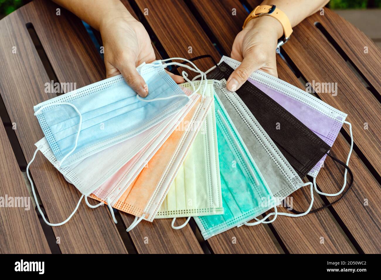 Quarantined woman choose colorful surgical masks to wear to prevent the spread of the