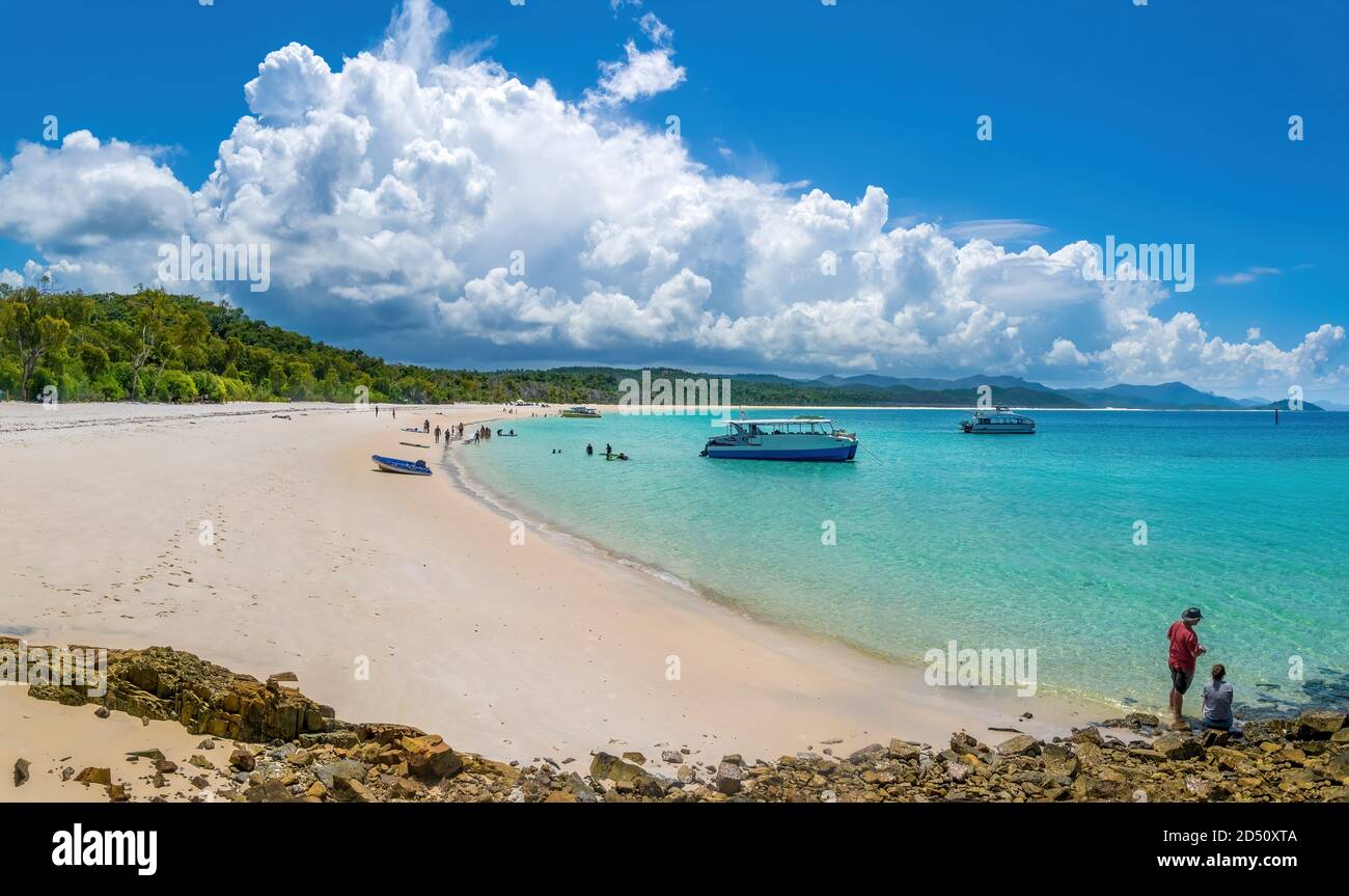 Whitsundays, Queensland, Australia - A group of people on the beach admiring the view and taking pictures at the Whitsunday Island. Stock Photo