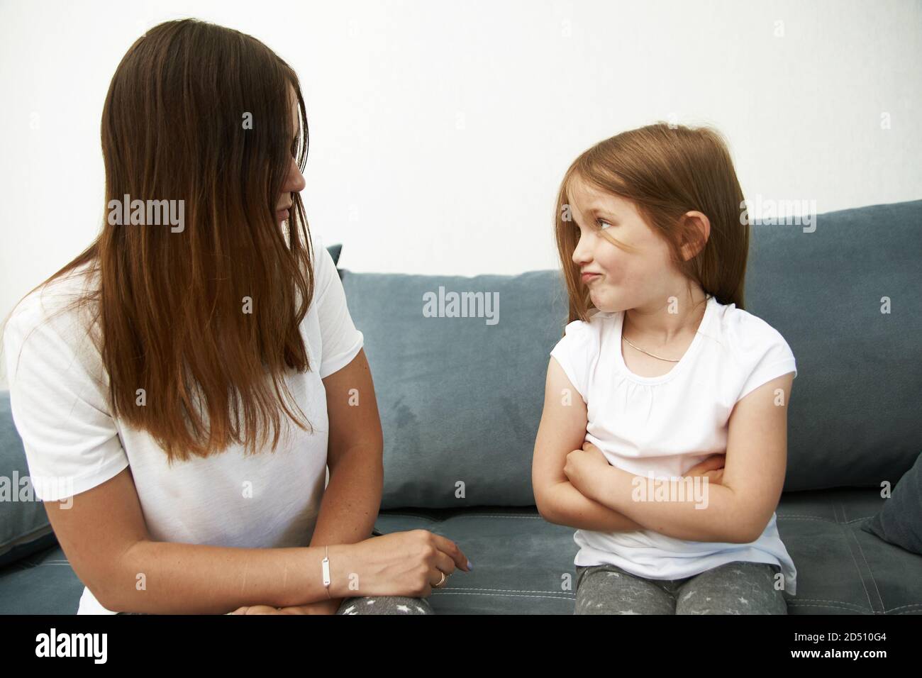 Mother teaches daughter. Mom scolds girl. The litlle girl is offended. Stock Photo