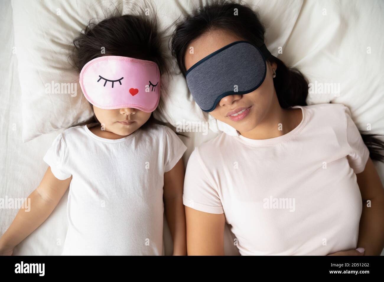 Top view Asian mother and little girl wearing masks sleeping Stock