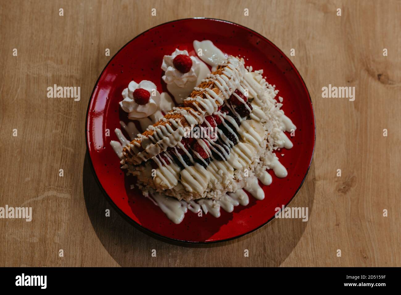 Tasty dessert with waffles, banana, raspberries, blackberries, banana ...
