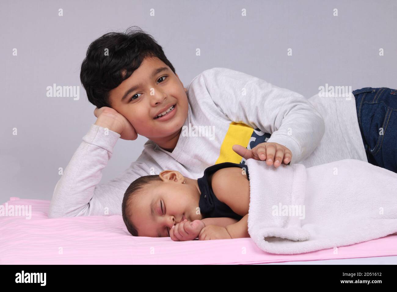 young Indian brother comforting his sister while she is asleep. Stock Photo
