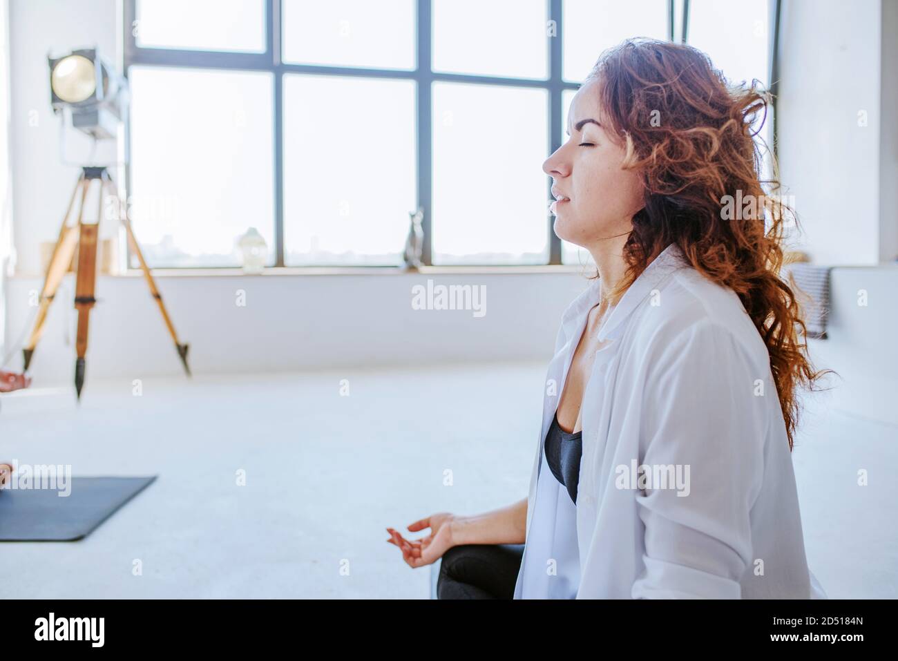 Young woman meditating sitting on the floor Stock Photo - Alamy