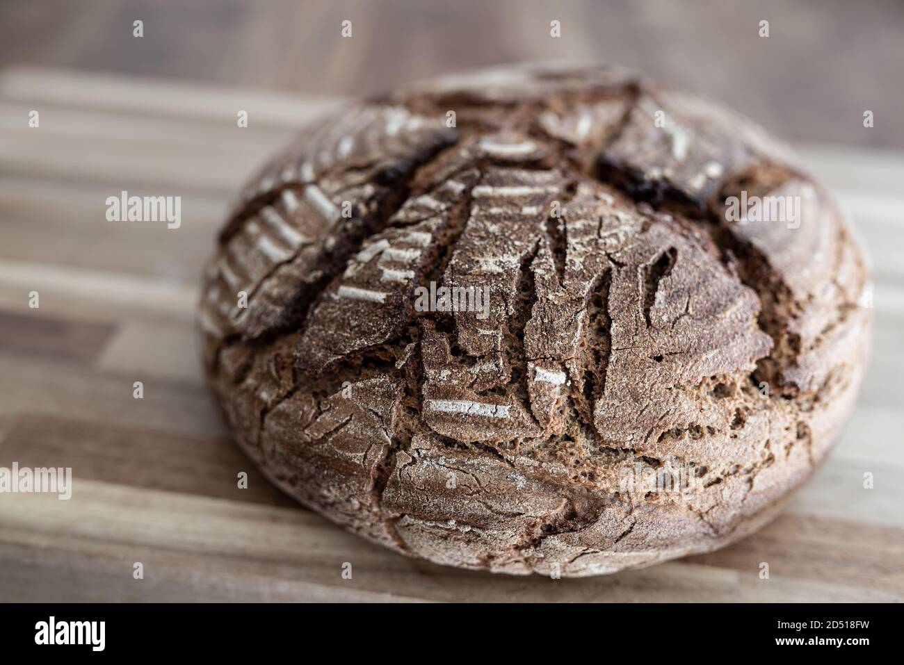 close-up of freshly baked homemade rye sourdough bread on wooden table Stock Photo