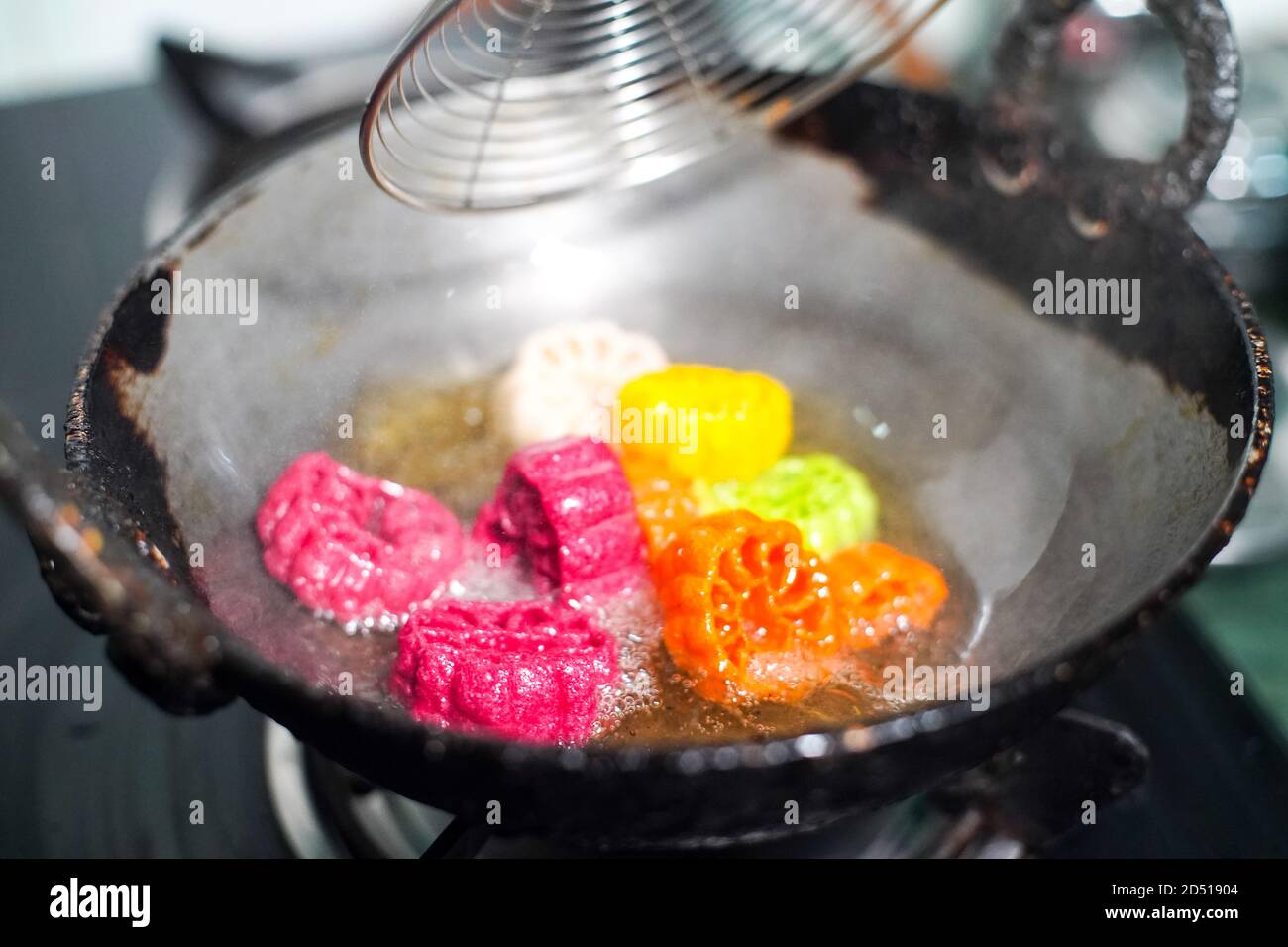 shot of colorful Fryums being deep fried in hot oil bubbling and