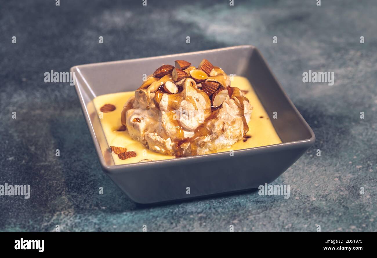 Floating island dessert made of meringue floating on vanilla custard