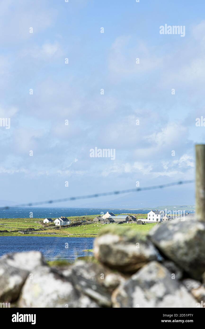 Small group of farmhouses and outbuildings seen over a dry stone wall along the Killeen loop walks near Louisburgh, County Mayo, Ireland Stock Photo
