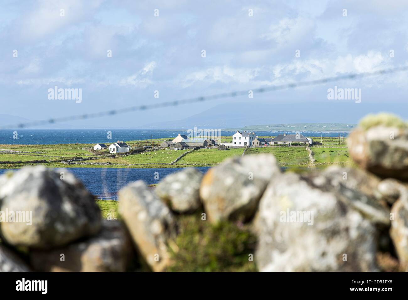 Small group of farmhouses and outbuildings seen over a dry stone wall along the Killeen loop walks near Louisburgh, County Mayo, Ireland Stock Photo
