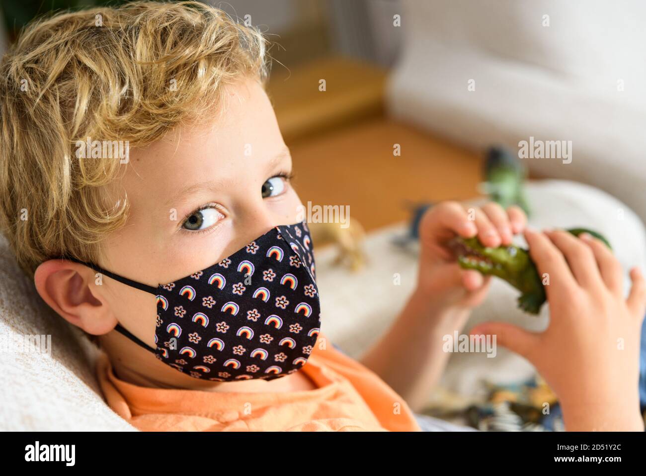 Child with mask confined at home during quarantine. Stock Photo
