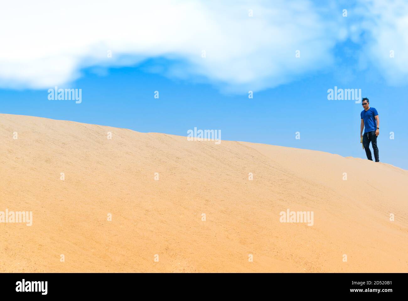 Young man in casual clothes walking forward in the desert Stock Photo