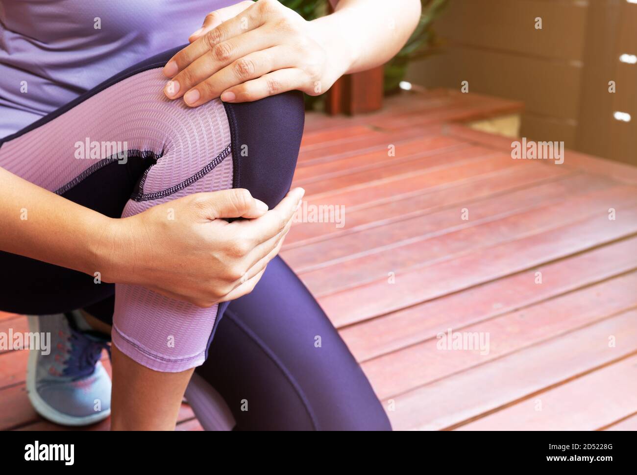 Knee pain. Young woman suffering knee injury while exercising and