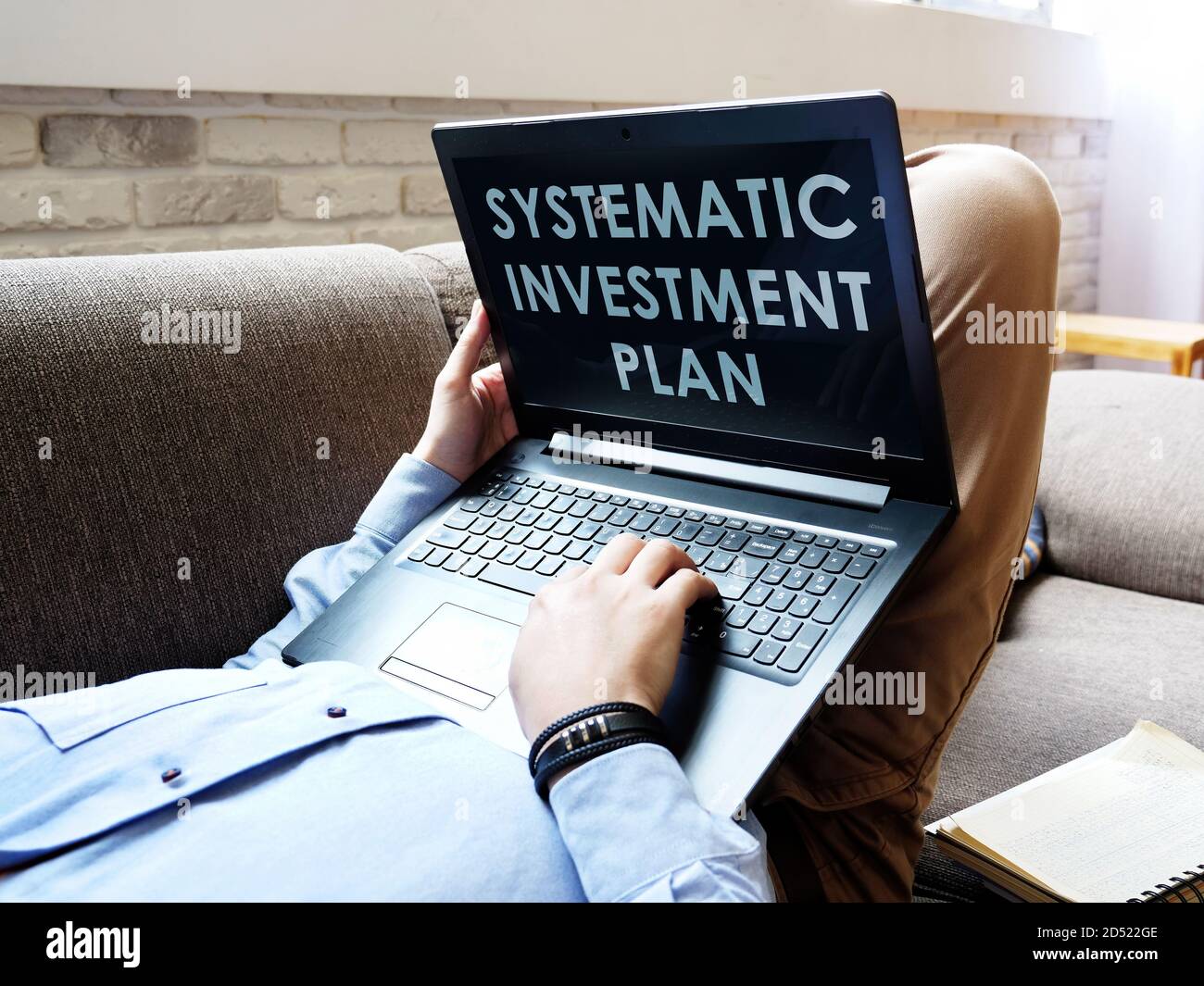 Systematic Investment Plan SIP. The man is reading on a laptop. Stock Photo