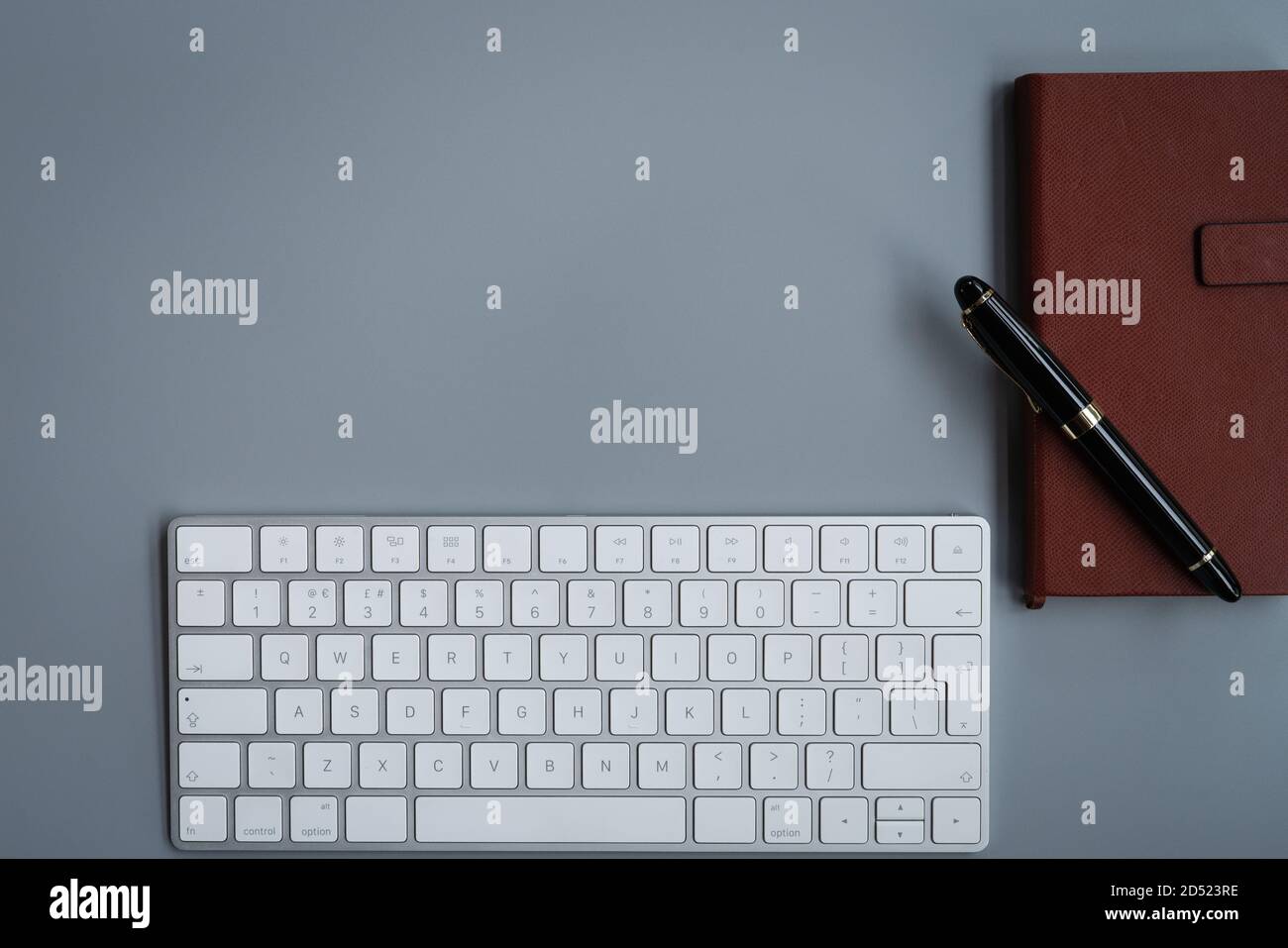 office table with computer keyboard, notebook and luxury pen. topview, copy space Stock Photo