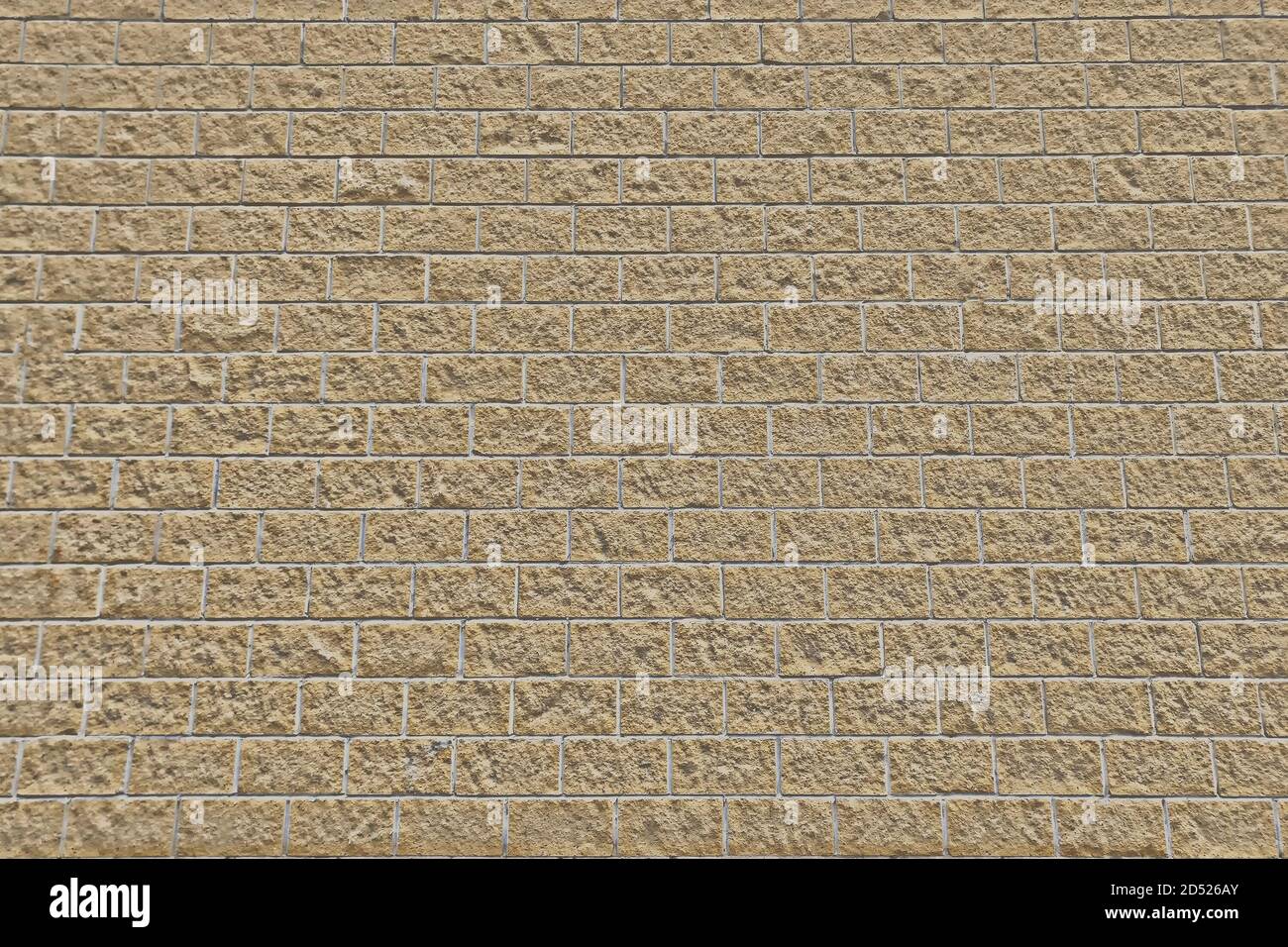 Beige brick wall texture. Rough masonry of stone blocks. Brick background of light brown limestone. Stock Photo